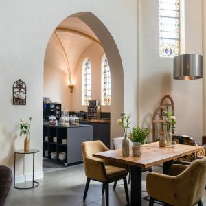 a dining room with a table and chairs at KerkHotel Biervliet in Biervliet