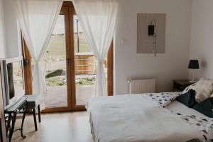 a bedroom with a bed and a sliding glass door at Málna Major in Mályinka