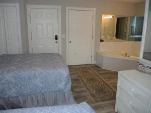 a bedroom with a bed and a bathroom with a tub at Studio Style Home 308L features Golf in Calabash