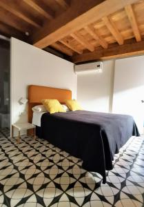a bedroom with a bed and a black and white floor at Apartamento Zocailla in Gata