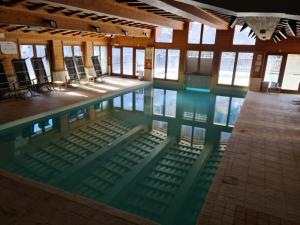 einen Pool mit Stühlen in einem Gebäude in der Unterkunft Arc 1950 Appartement de standing Refuge du Montagnard, vue incroyable sur le Montblanc, skis aux pieds Accès spa et piscine in Arc 1950