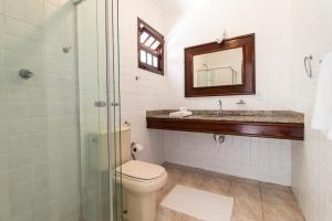 
a bathroom with a toilet a sink and a shower at Hotel Villa Di Capri in Ubatuba
