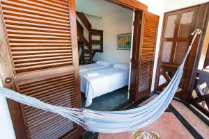 a hammock in a room with a bed and a bedroom at HOTELARE Hotel Villa Di Capri in Ubatuba