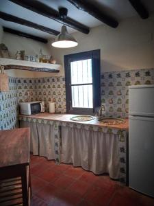 cocina con encimera con fregadero y ventana en Casa Juncaria, en Yunquera