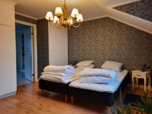 a bedroom with two beds and a chandelier at Sjötorps Säteris Bed & Breakfast Flygeln in Larv +41 photos