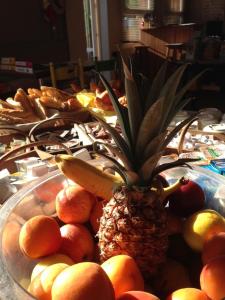 a pineapple in a bowl of fruit on a table at Hotel du Cap in Cap-Ferret