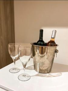 two wine glasses and a bucket of wine bottles at Nosso Recanto Pérola in Capitólio