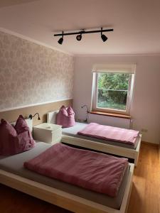 1 dormitorio con 2 camas y ventana en Mühlenloft Hameln, en Hessisch Oldendorf