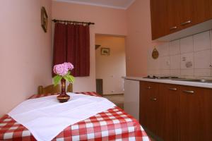 a kitchen with a vase of flowers on a table at Apartments Neda - Poreč South in Poreč