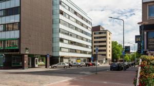 a city street with cars parked in front of buildings at Borg Housing City Central in Pori
