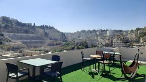 a balcony with tables and chairs and a view of a city at Layaali Amman Hotel in Amman