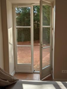 une porte ouverte avec vue sur la cour dans l'établissement Un air de Toscane, à Salles-Arbuissonnas-en-Beaujolais