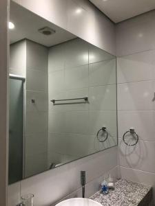 uma casa de banho com um espelho e um lavatório em Flat 5 estrelas-novo e charmoso na Granja Viana em Cotia