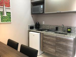 a kitchen with a sink and a counter top at Flat 5 estrelas charmoso na Granja Viana in Cotia