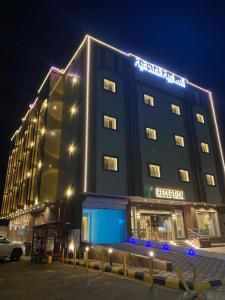 a hotel building with a sign on it at night at شقق السامية للشقق المخدومة in Sharurah