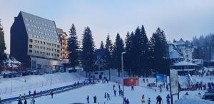 Un grupo de personas en la nieve en una pista de esquí. en Olimpijska Kuća Jahorina, en Jahorina