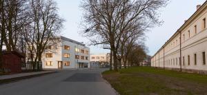 an empty street with buildings and trees on the side at Střešní apartmán s terasou in Hradec Králové