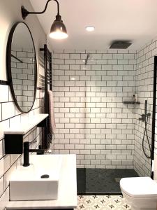 Emérita Luxury Home في برغش: حمام مع حوض أبيض ومرآة