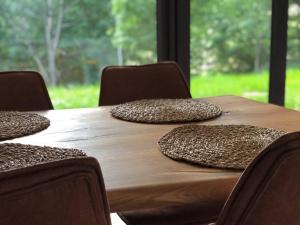 una mesa de madera con sillas y almohadas. en Apartmán Borůvka en Železná Ruda