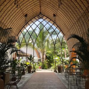 a conservatory with an archway with plants in it at Tropical Temple Siargao Resort in General Luna