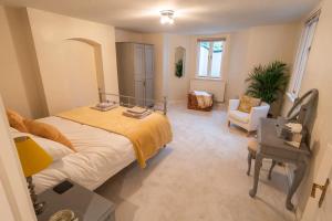 1 dormitorio con 1 cama grande con manta amarilla en The Snug en Great Malvern