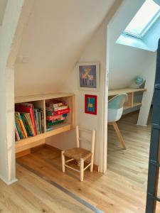 ヴィムルーにあるGite Beaulieuの本棚、椅子、デスクが備わる客室です。