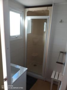 a bathroom with a shower and a glass door at Mobile-Home in Argelès-sur-Mer
