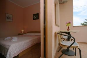 a bedroom with a bed and a table and a chair at Apartments Neda - Poreč South in Poreč