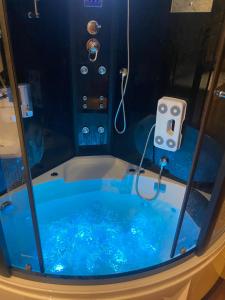 a blue tub with a shower in a room at Niine apartment 11 in Haapsalu