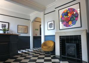 a living room with a fireplace and a chair at The Coach House Suffolk in Lowestoft