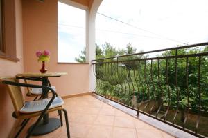 a balcony with a table and a chair and a window at Apartments Neda - Poreč South in Poreč