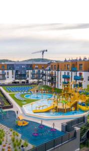 um complexo de apartamentos com um parque aquático com um escorrega aquático em Meduza w Bel Mare em Międzyzdroje