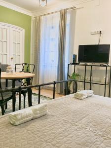 肖普朗的住宿－Fidelissima Apartman，一间卧室配有一张床、一张桌子和一台电视。