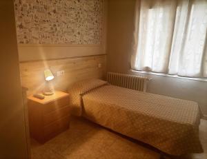 a bedroom with two beds and a lamp on a night stand at Hostal Isla Cristina Mataro in Mataró