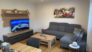 a living room with a couch and a flat screen tv at Ferienhaus Geest und Moor 1 in Großheide