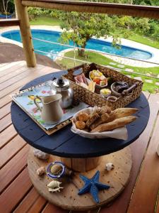 una mesa con una bandeja de comida en la cubierta en La Luciole Ecolodge en Paraty