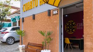 a building with a bench in front of a restaurant at HOSTEL CUARTO in Sao Paulo