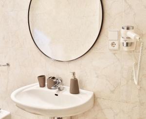 Rosa Rooms Meran في ميرانو: حمام مع حوض ومرآة