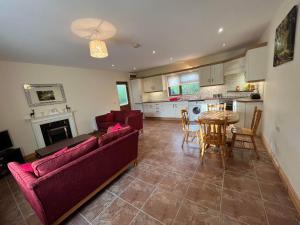 sala de estar con sofás, mesa y cocina en Burnmon Cottage en Belcoo