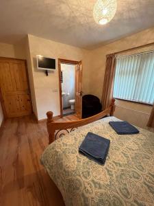 a bedroom with a bed with two towels on it at Burnmon Cottage in Belcoo
