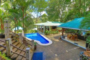 a home with a swimming pool and a house at Casa de Paz- Portasol Vacation Rentals in Matapalo