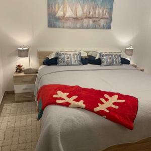 łóżko z czerwonym kocem z bałwanem w obiekcie La Dolce Vita Apartment w mieście Posedarje