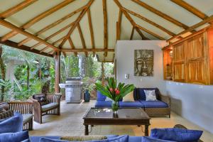 a living room with a blue couch and a table at Casa de Paz- Portasol Vacation Rentals in Matapalo