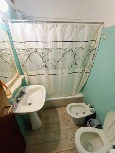 y baño con lavabo, aseo y cortina de ducha. en EF DEPARTAMENTOS Centro Cochera, en Mar del Plata