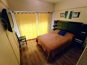 1 dormitorio con 1 cama grande y 1 silla en EF DEPARTAMENTOS Centro Cochera, en Mar del Plata