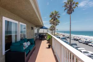 a balcony with a couch and a view of the beach at Beachwalk Villas in Carlsbad
