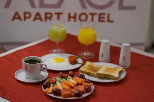 een tafel met een bord ontbijtproducten en twee glazen sinaasappelsap bij El Rey Palace Hotel in La Paz