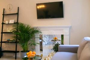 a living room with a fireplace with a tv on the wall at Rycerska - Stone Steps Apartments in Warsaw
