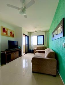 a living room with a couch and a flat screen tv at Apartamento Praia da Enseada in Guarujá