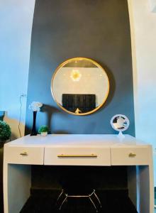 a white dresser with a mirror on a blue wall at Pasavento - Modern Black Suite in Camaceyes
